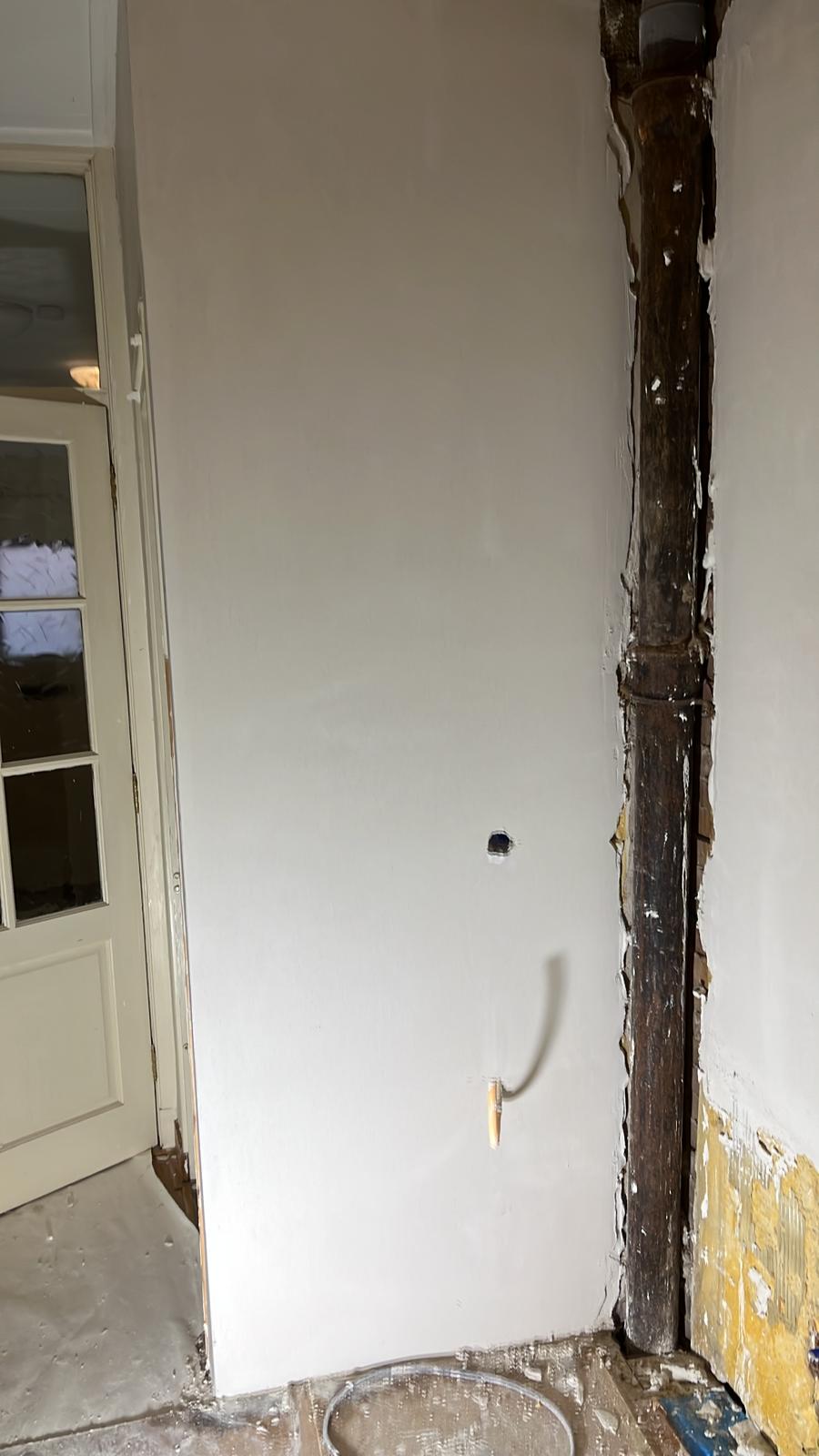 Wand naast leidingschacht hersteld