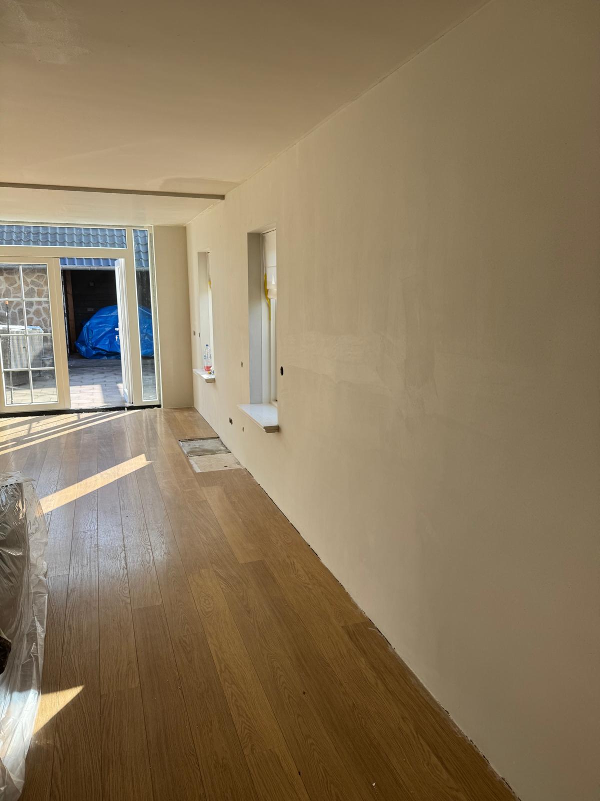 Woonkamer strak gestuukt, klaar voor schilderwerk